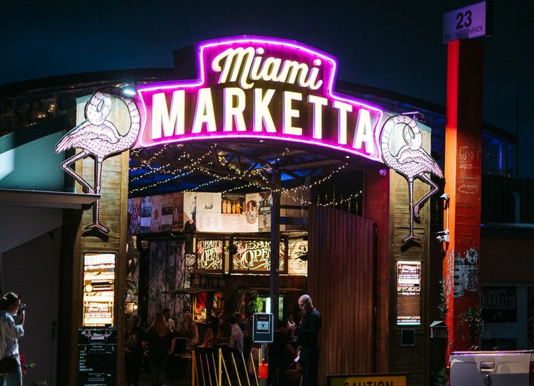 Outside the Miami Marketta at night with neon lights
