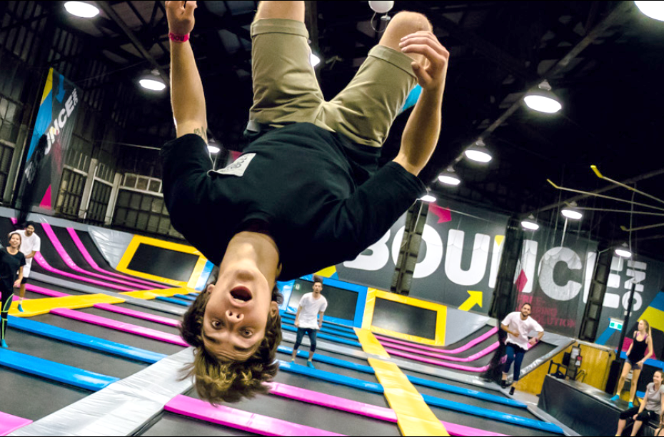 Boy upside down jumping on trampoline