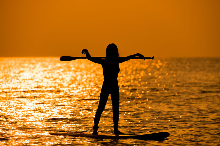 silhouette of a woman on a standup paddleboard